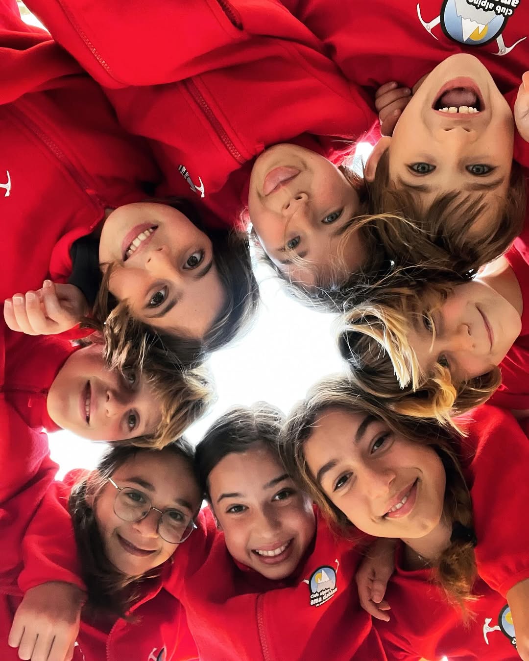 Selfi del equipo de competición en círculo, con la equipación roja del club