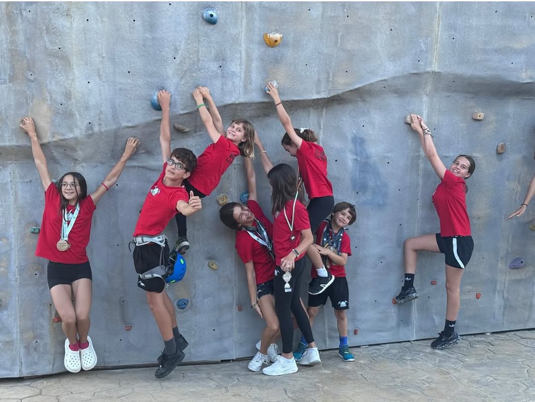 El equipo colgado del rocódromo con sus medallas