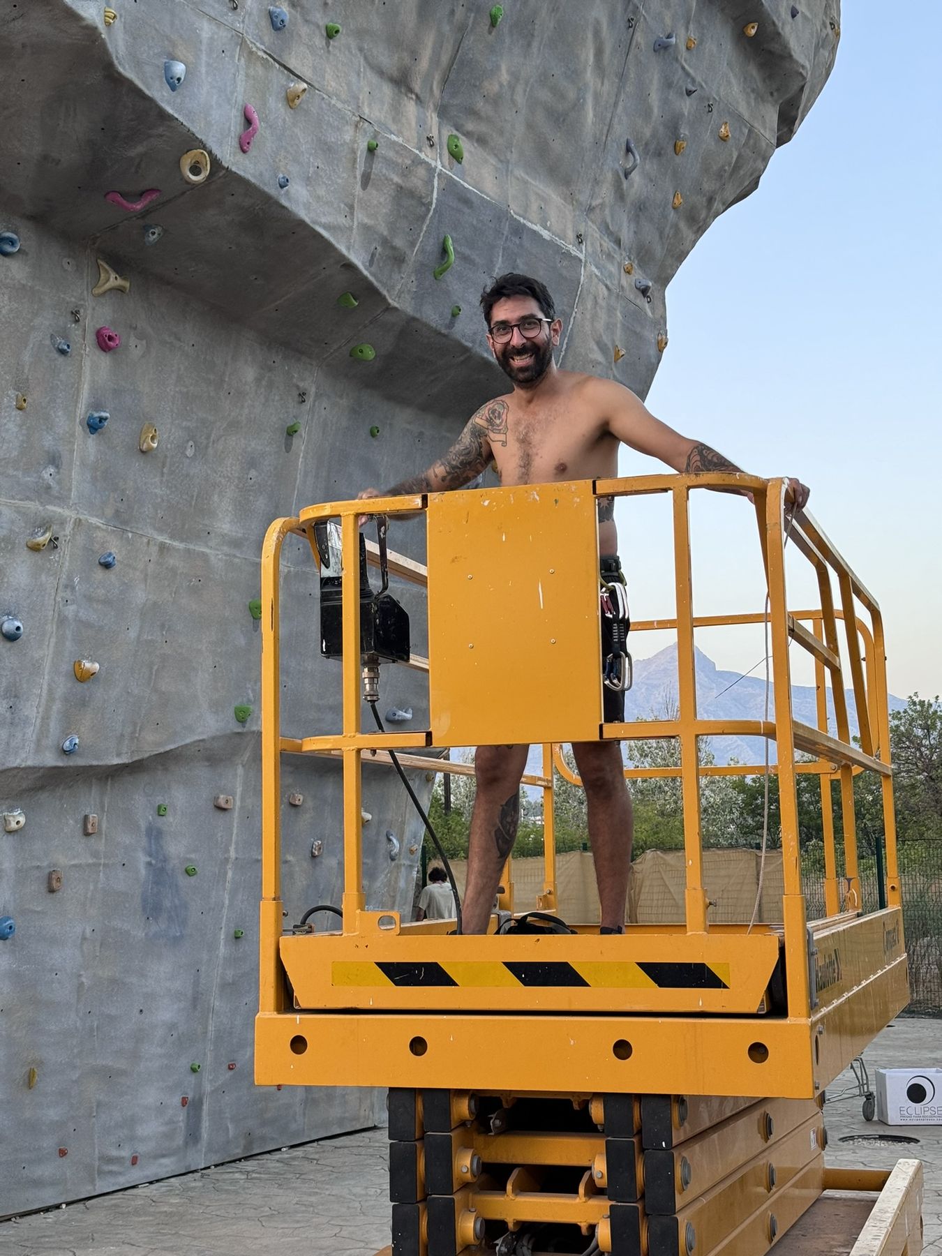 Un equipador trabaja en el muro desde una plataforma de tijera